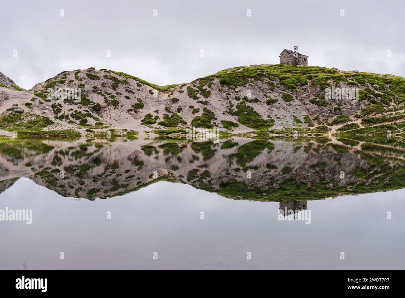 Die kleine Kirche und die Reflexion der alpinen Landschaft im ruhigen Wasser, OLBE Seen, Sappada, Karniche Alpen, Provinz Udine Stockfoto