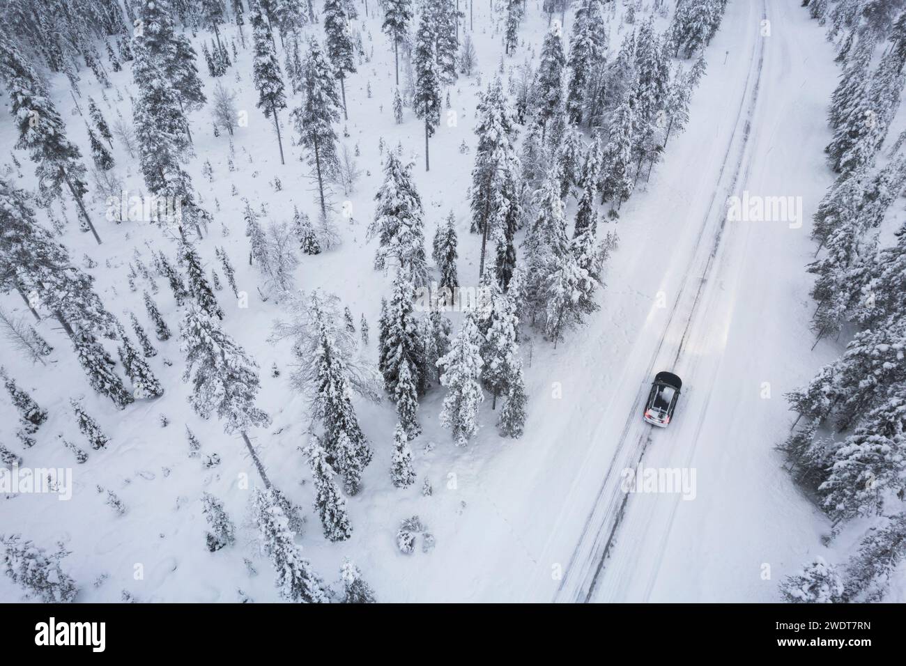 Aus der Vogelperspektive eines Autos, das durch den schneebedeckten Wald auf vereister Straße fährt, Akaslompolo, Finnisch-Lappland, Finnland, Skandinavien, Europa Stockfoto