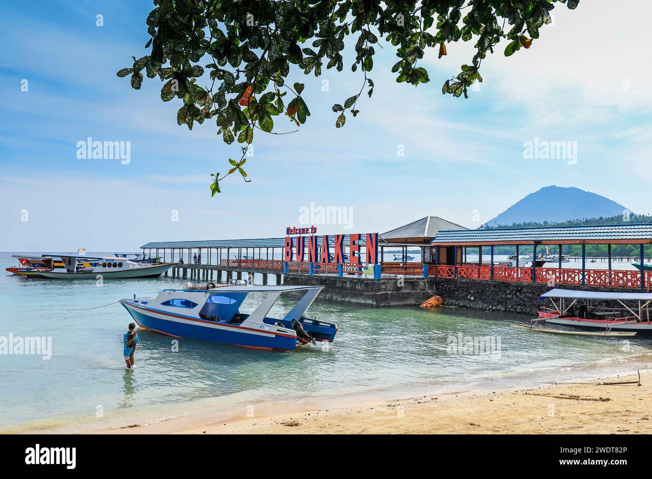 Bootssteg und Willkommensschild für Touristenboote in der zentralen Bucht dieser beliebten Urlaubs- und Tauchinsel Bunaken Island, Nord-Sulawesi, Indonesien Stockfoto