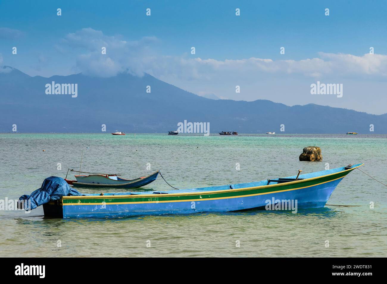 Kleine Boote, die mit dem Festland jenseits dieses korallengesäumten Urlaubs- und Tauchziels liegen, Bunaken Island, Sulawesi, Indonesien Stockfoto