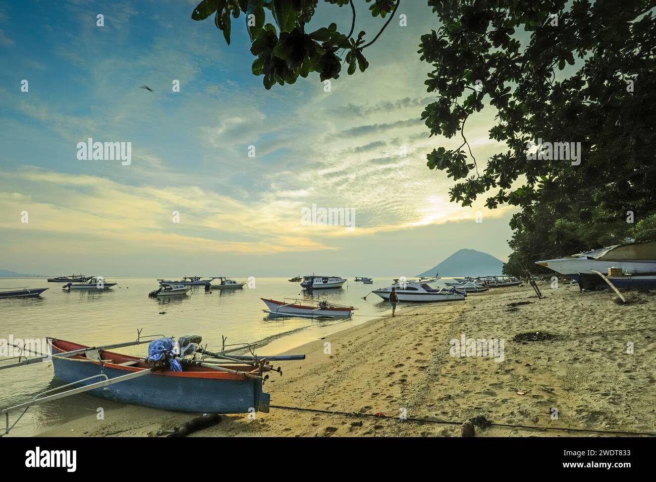 Boote vom Stadtstrand bei Sonnenuntergang mit der Insel Manadotua dahinter auf dieser Urlaubs-Tauchinsel Bunaken, Nord-Sulawesi, Indonesien, Südostasien, Asien Stockfoto