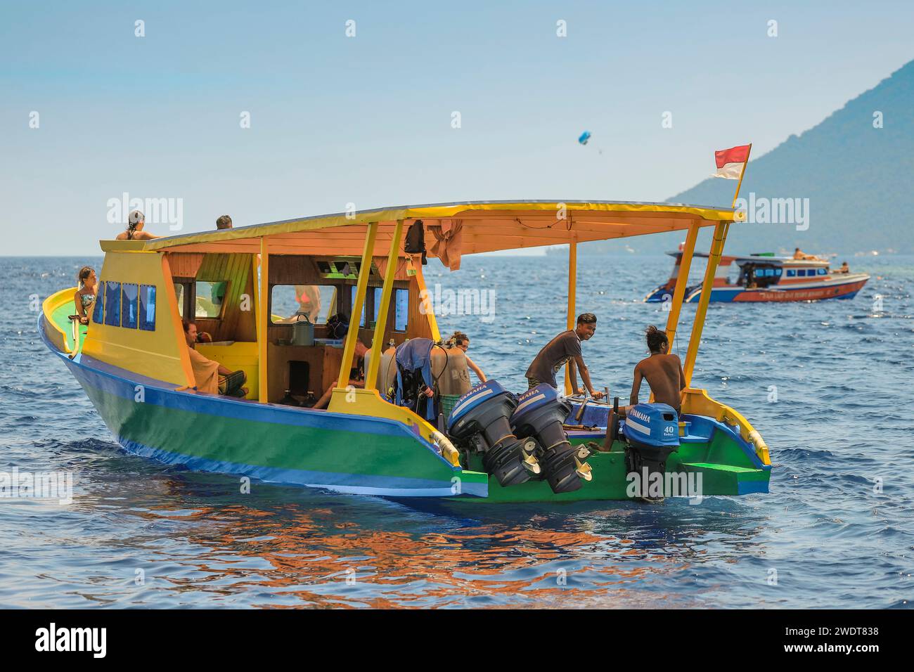 Tauchboot mit jungen ausländischen Touristen und Crew von Korallen gesäumten Urlaubs- und Tauchinsel, Bunaken, Nord-Sulawesi, Indonesien, Südostasien, Asien Stockfoto