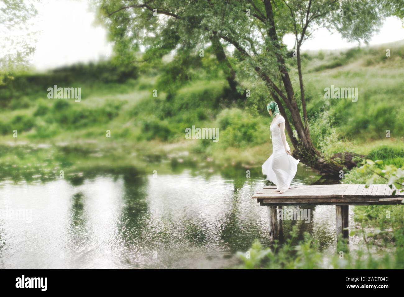 Surreale Frau tanzt inmitten grüner Natur Stockfoto