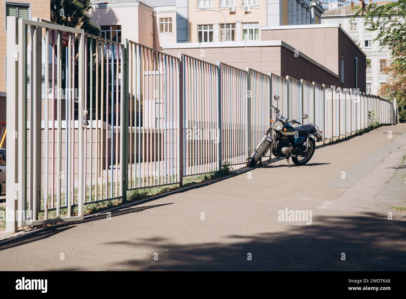 Motorrad in der Nähe eines langen Zauns. Hochwertige Fotos Stockfoto