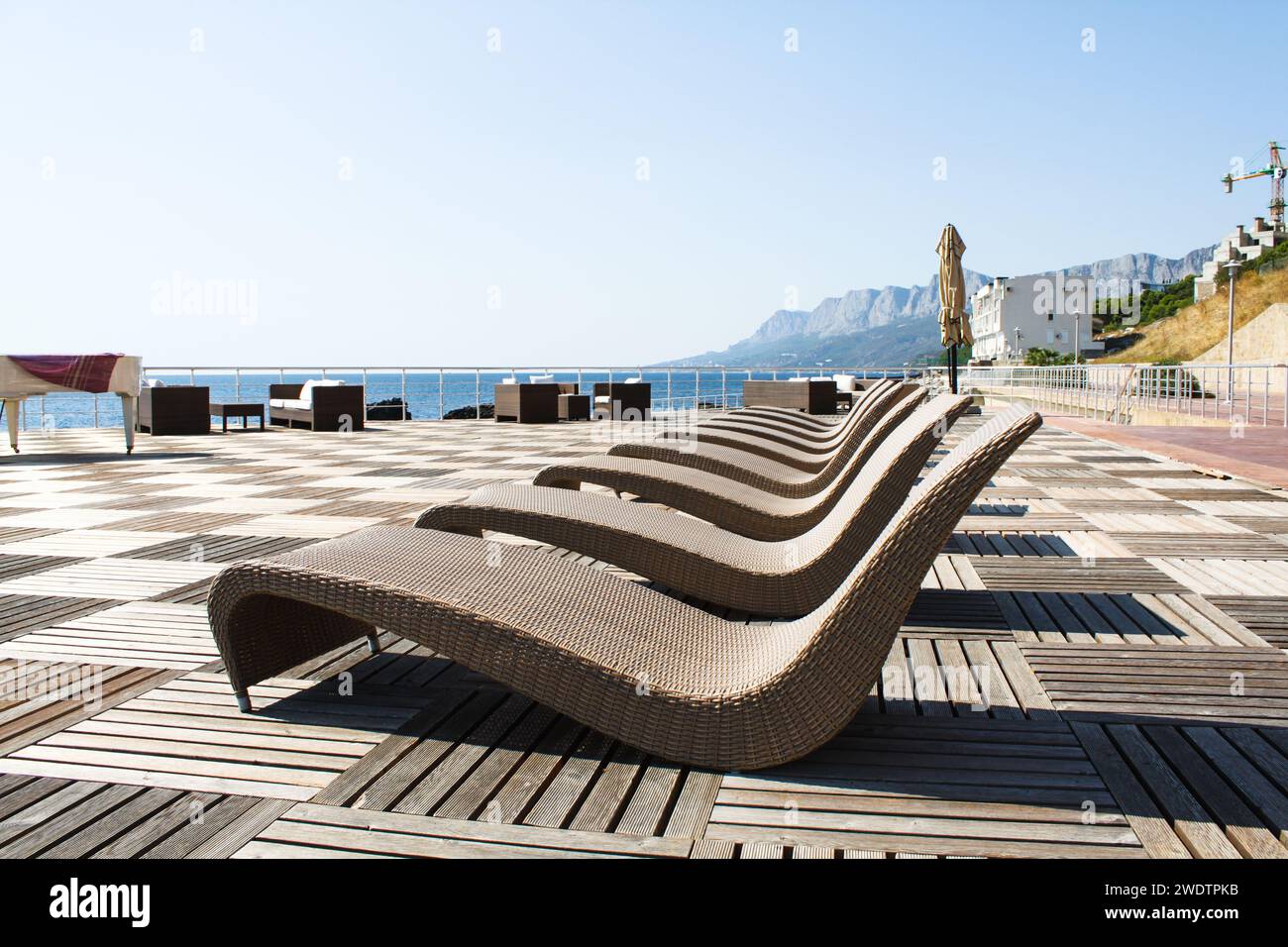 Liegestühle am Meer vor der Kulisse der Berge. Hochwertige Fotos Stockfoto