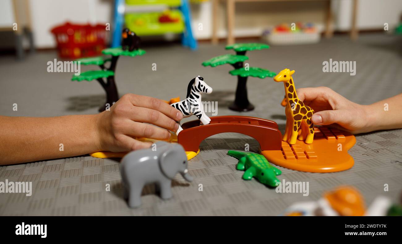 Kinderspiel mit Tierfiguren, Savanne, Händen. Hochwertige Fotos Stockfoto