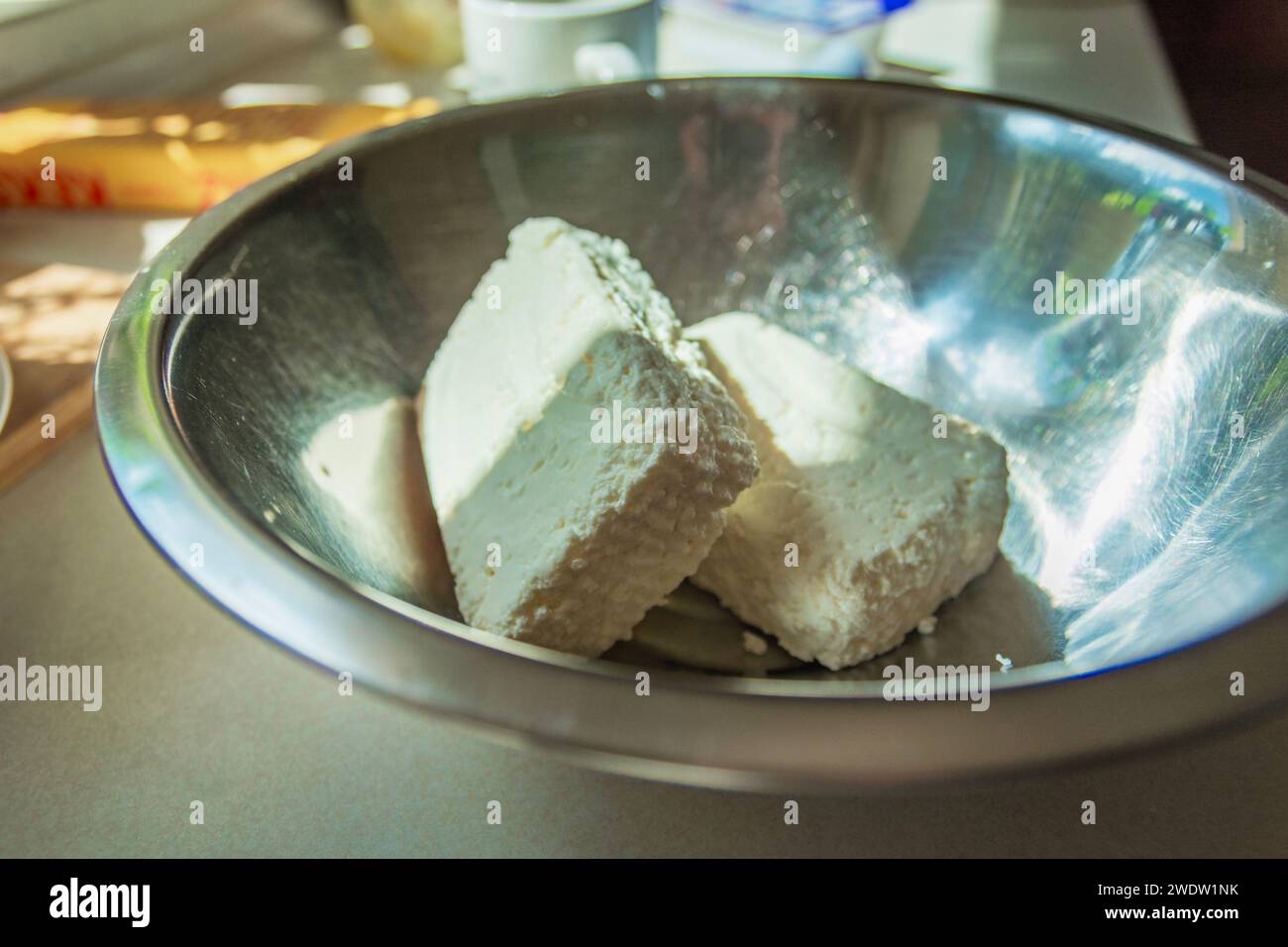 Weiße Hüttenkäsewürfel in einer Aluminiumschale, Ergänzungen zu kulinarischen Gerichten Stockfoto