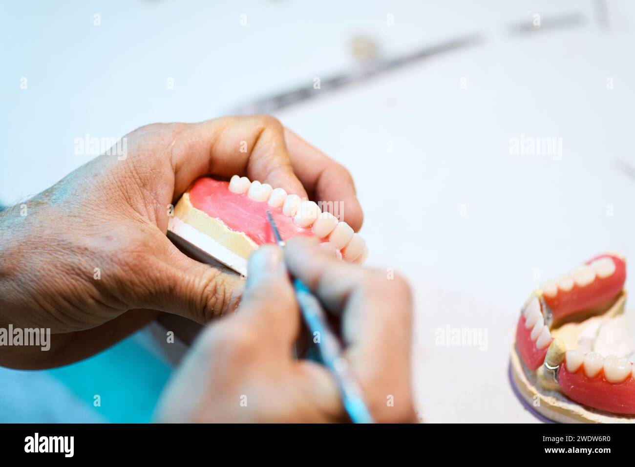 Nahaufnahme der prothetischen Handwerkskunst, die die Detailarbeit zur Herstellung einer Zahnprothese zeigt Stockfoto