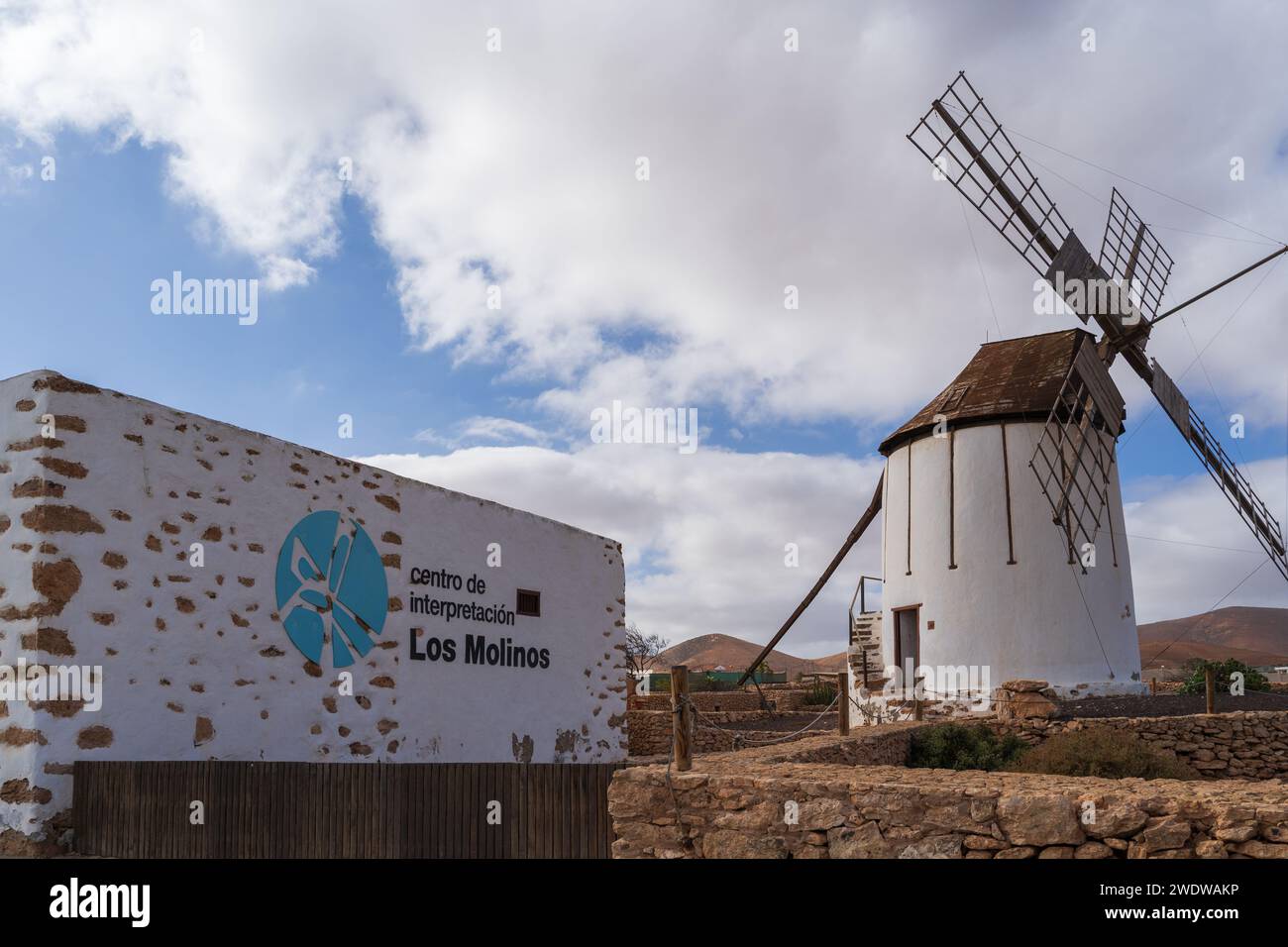 Eine traditionelle weiße Windmühle und ein Schild für das Windmill Interpretation Center 'Los Molinos' in Tiscamanita, Fuerteventura, Spanien. Stockfoto