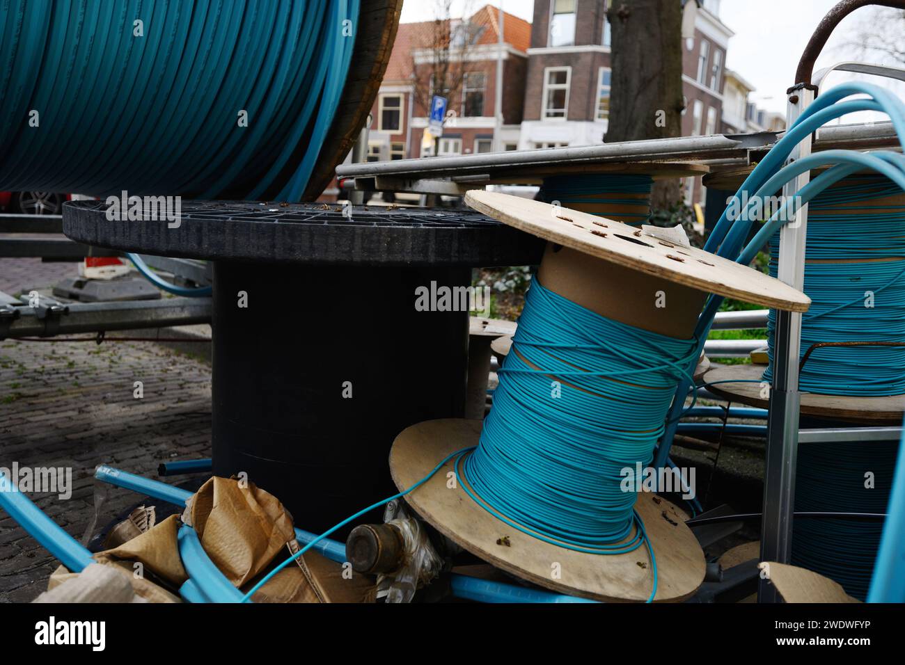 Städtische Kommunikationsleitungen für Reparaturmaterialien für städtische Infrastruktur und Straßenrenovierung. Kabeltrommeln für Straßenbauarbeiten Stockfoto
