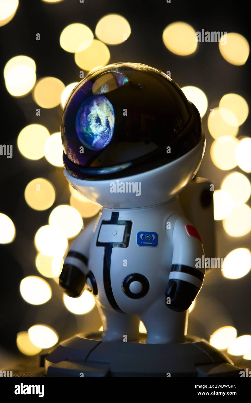 Astronaut im Weltraum, der die Erde in seinem Helm reflektiert, mit vielen verschwommenen Sternen im Hintergrund Stockfoto