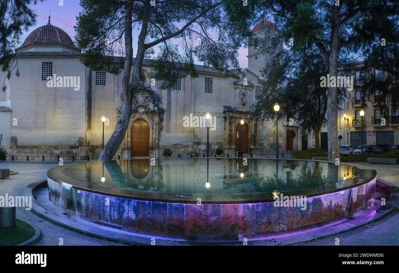 Orihuela, Alicante, Spanien - in der Abenddämmerung leuchten die Straßenlaternen rund um das beleuchtete Wasserspiel am de La Madre Elisea in Orihuela, Spanien. Stockfoto