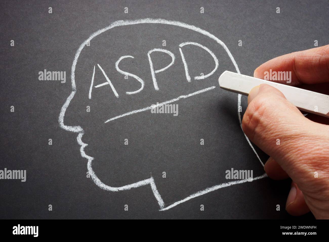 Eine Hand schrieb die Abkürzung ASPD antisoziale Persönlichkeitsstörung in Kreide. Stockfoto