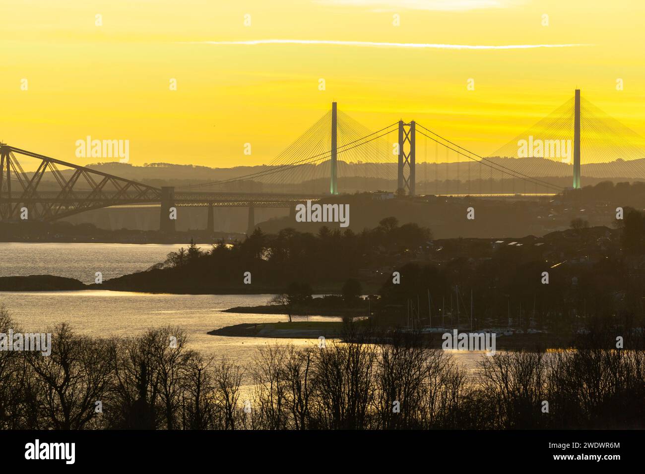 Alle drei Brücken über den Firth of Forth bei Sonnenuntergang von Dalgety Bay, Fife. Stockfoto