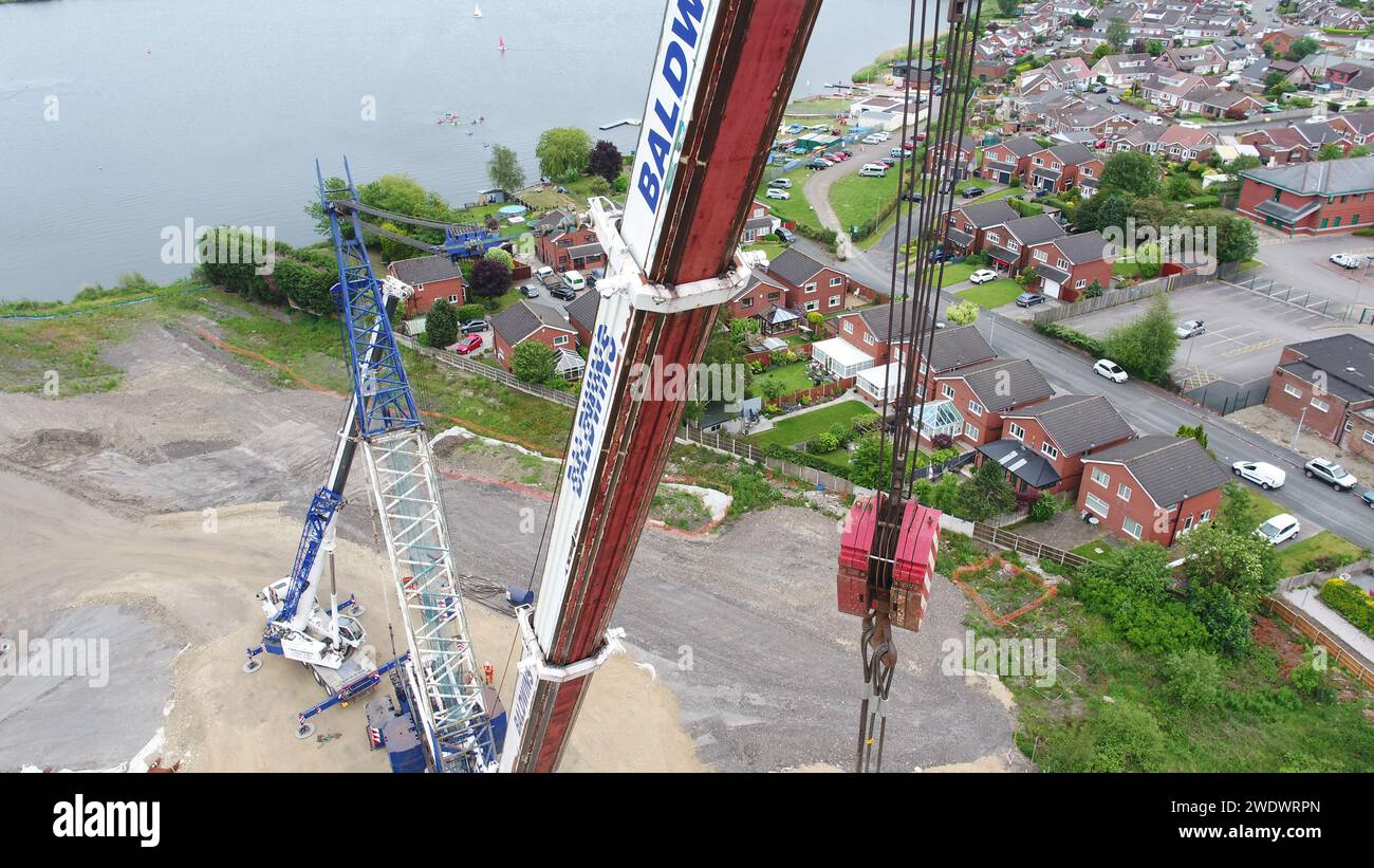 Luftaufnahmen eines schweren Baldwins-Krans, der Brückenbalken über der Poolstock Lane während des A49 Link Road-Projekts von Jones Bros in Wigan in Position bringt Stockfoto