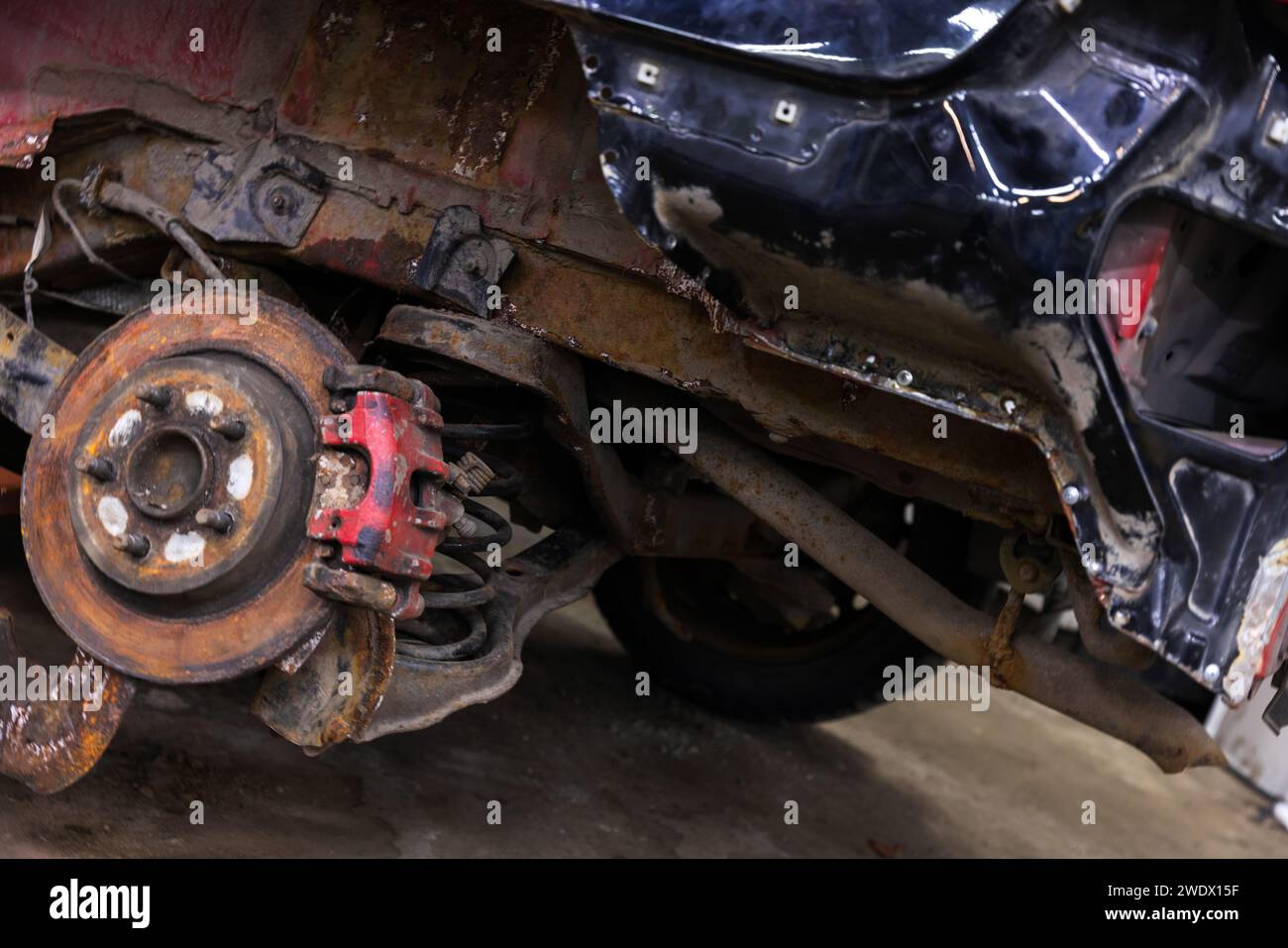 Nahaufnahme von Bremsscheibe und Federung eines alten kaputten Autos nach einem Verkehrsunfall Stockfoto