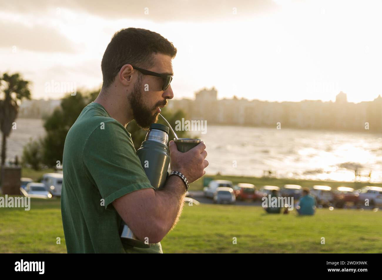 Mann trinkt Chimarrao, Mate (eine Infusion von Yerba Mate mit heißem Wasser) bei Sonnenuntergang in uruguay Stockfoto