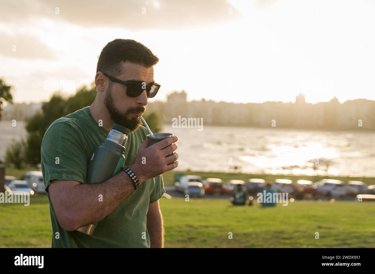 Mann trinkt Chimarrao, Mate (eine Infusion von Yerba Mate mit heißem Wasser) bei Sonnenuntergang in uruguay Stockfoto