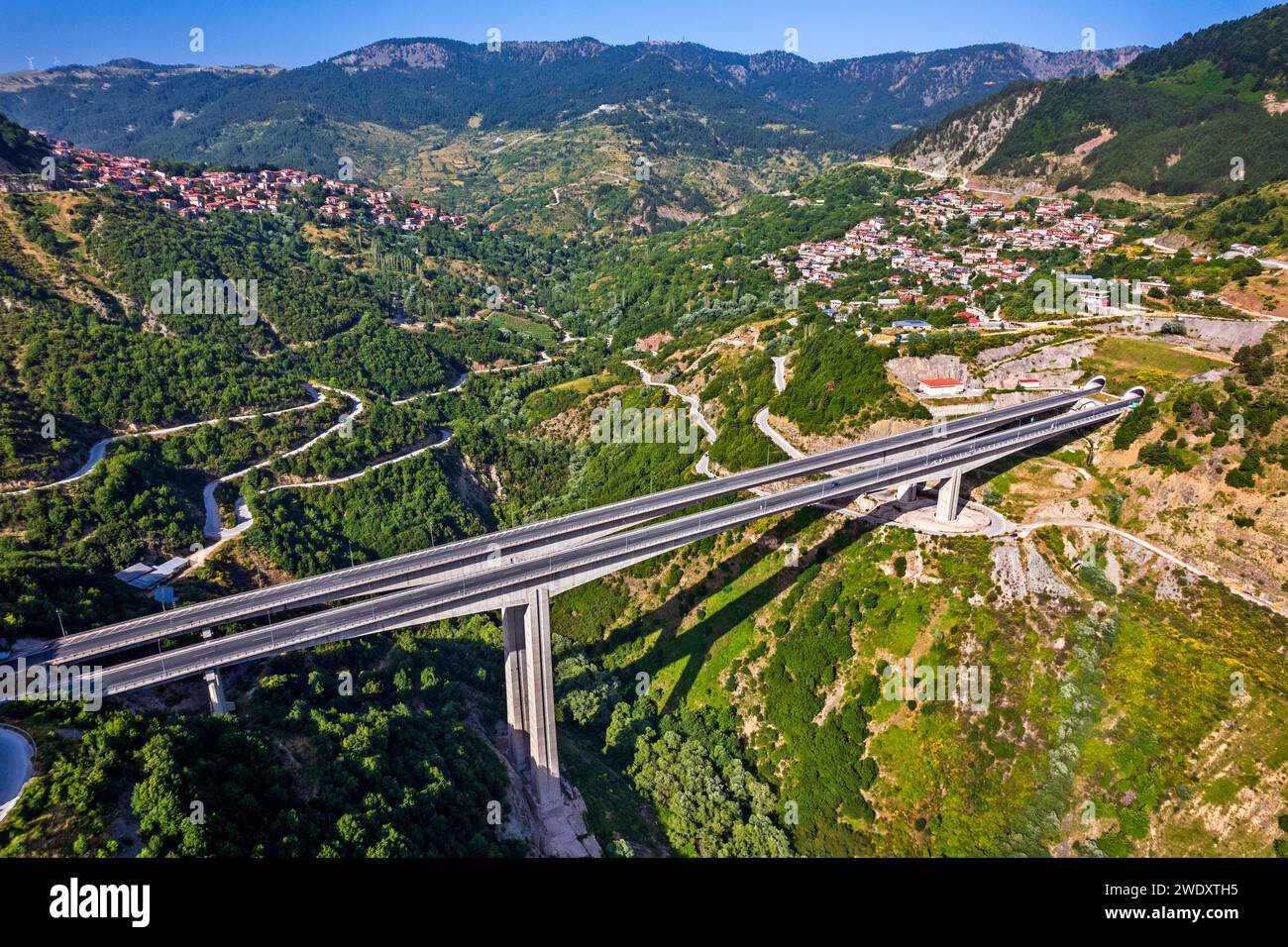 Eine der Brücken der Egnatia Road. Im Hintergrund die Stadt Metsovo (links) und das Dorf Anilio (rechts). Ioannina, Epirus, Griechenland. Stockfoto