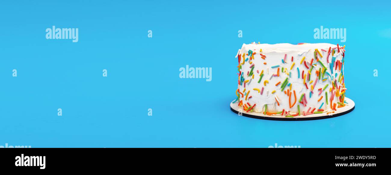 Bento Geburtstagskuchen auf blauem Banner Hintergrund. Kleines Dessert mit farbenfroher Zuckerdekoration Stockfoto
