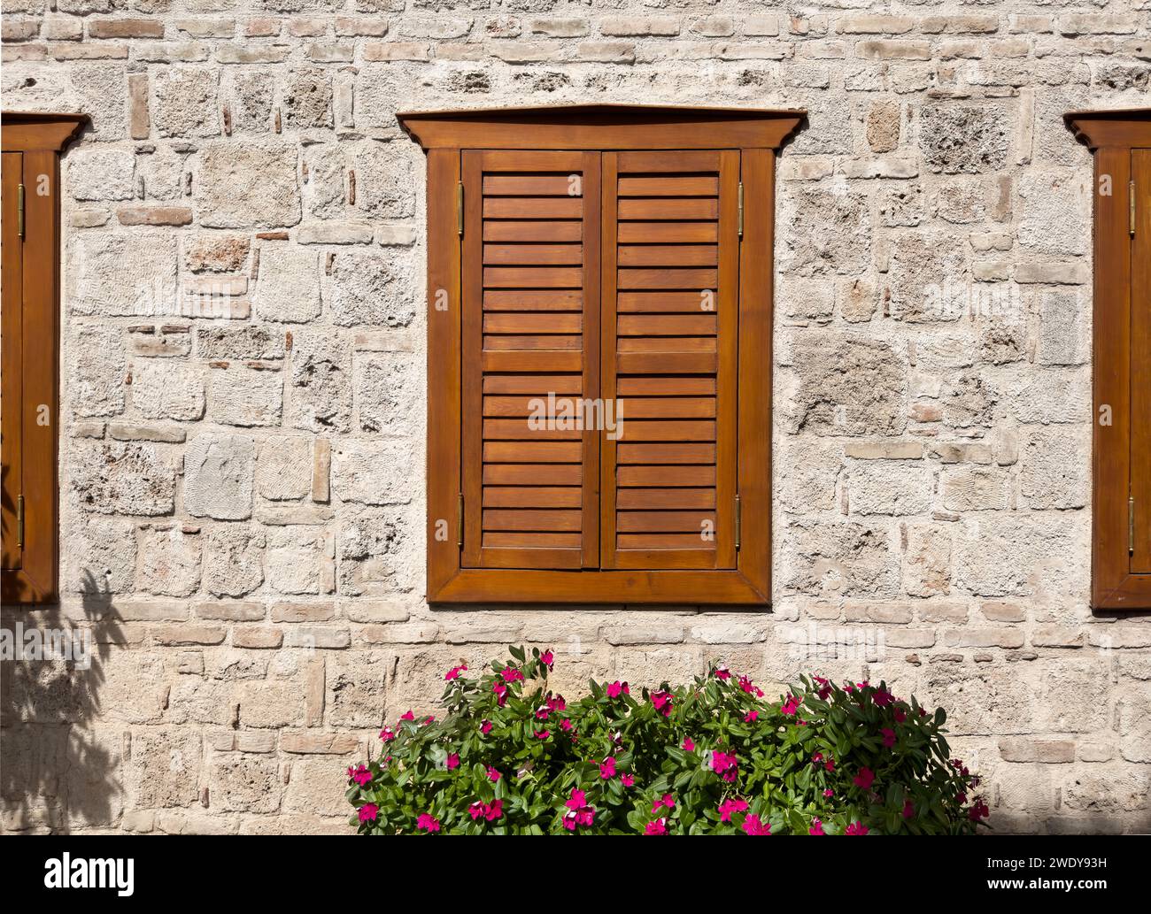 Alte Architektur mit Holzläden an alten Fenstern, Steinmauer Stockfoto
