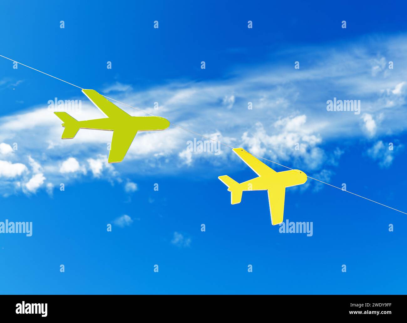 Gelbe Spielzeugflugzeuge fliegen in blauem Himmel mit Wolken. Travel Dreams Konzept Stockfoto