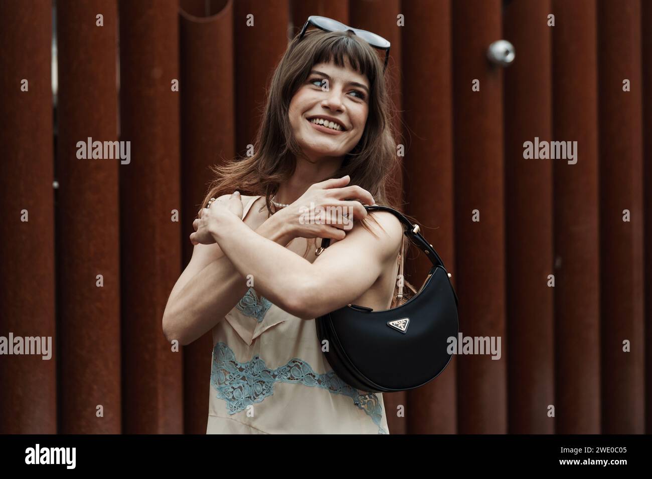 Lea Naumann trägt eine schwarze Prada-Tasche und ein cremeweißes Kleid, vor der Sportmax-Show während der Mailand Fashion Week im Frühjahr/Sommer 2024. Stockfoto