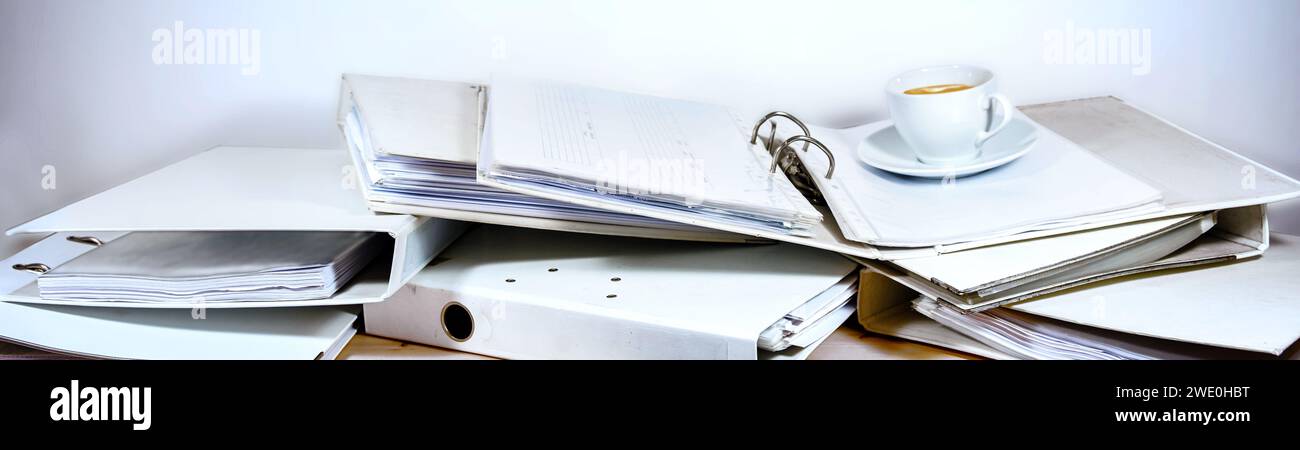 Unordentlicher Bürotisch voller Ringordner und Kaffeetasse, großes Panoramaformat, Business-Konzept für Stress und Überlastung am Arbeitsplatz, Kopierraum, ausgewählt Stockfoto