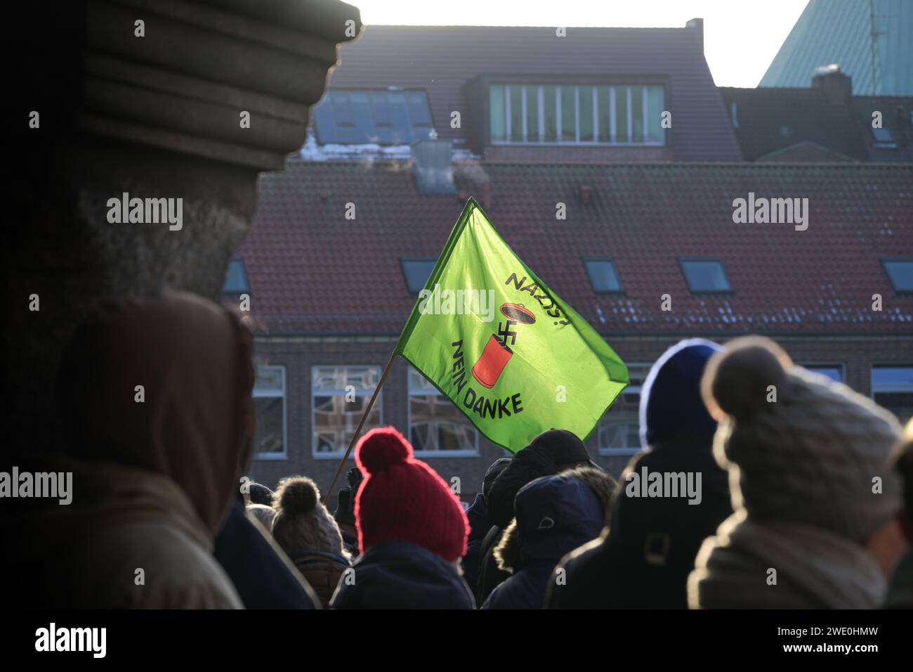 Lübeck, 22. Januar 2024: Grüne Fahne mit Hakenkreuz, die in einen Mülleimer geworfen wird, und Text - Nazis nein danke - bei der Demonstration gegen Rassismus Stockfoto