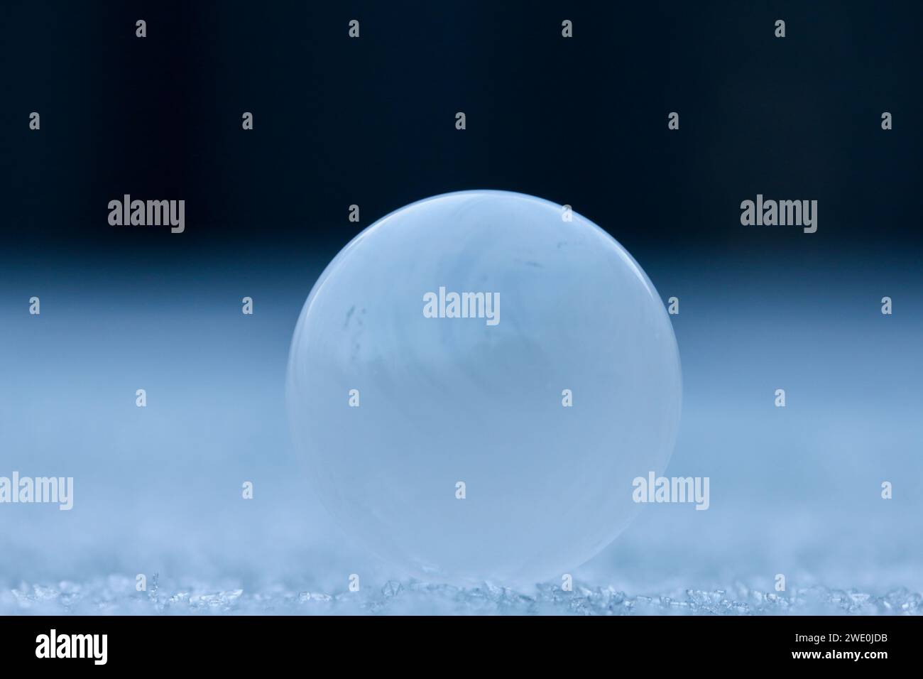 Eine Blase, gefroren in der Zeit, wie ein Planet, oder ein Mond, der an einem nebeligen Horizont aufsteigt Stockfoto