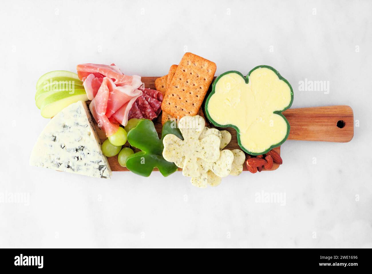 Charcuterie-Tafel mit dem Thema St. Patricks Day vor weißem Marmorhintergrund. Auswahl an Käse-, Fleisch-, Obst- und Gemüsevorspeisen. Draufsicht. Stockfoto