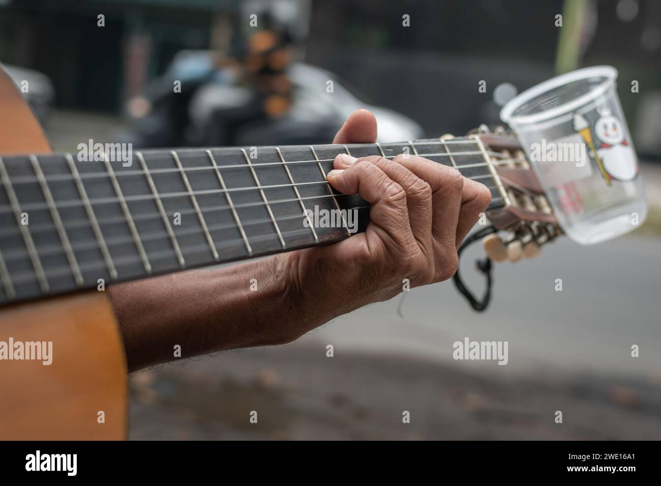 Ein älterer blinder Straßenmusiker singt und spielt seine Gitarre. Stockfoto