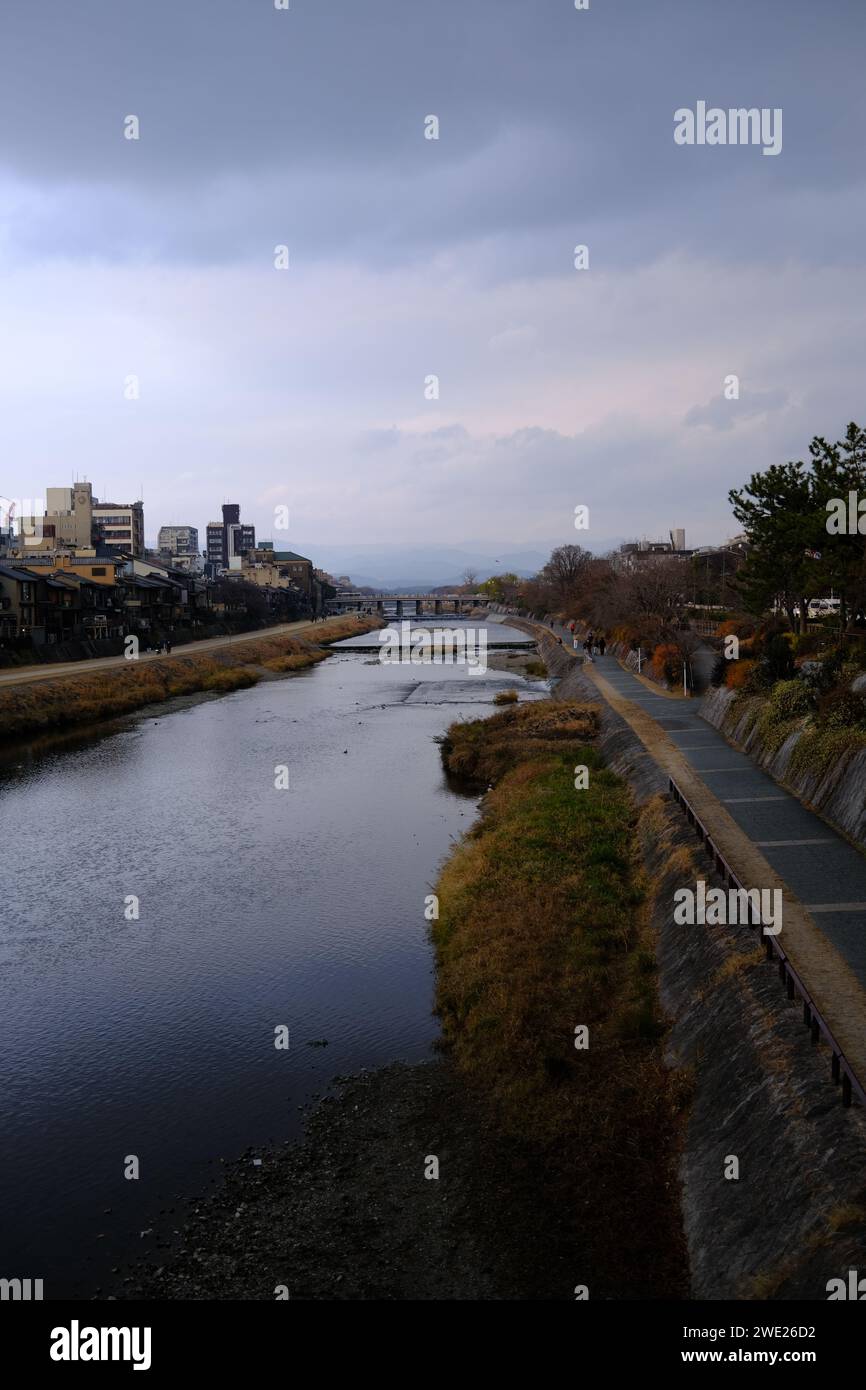 Ruhige Flusslandschaft in Kyoto mit bewölktem Himmel und Bergen in der Ferne. Stockfoto
