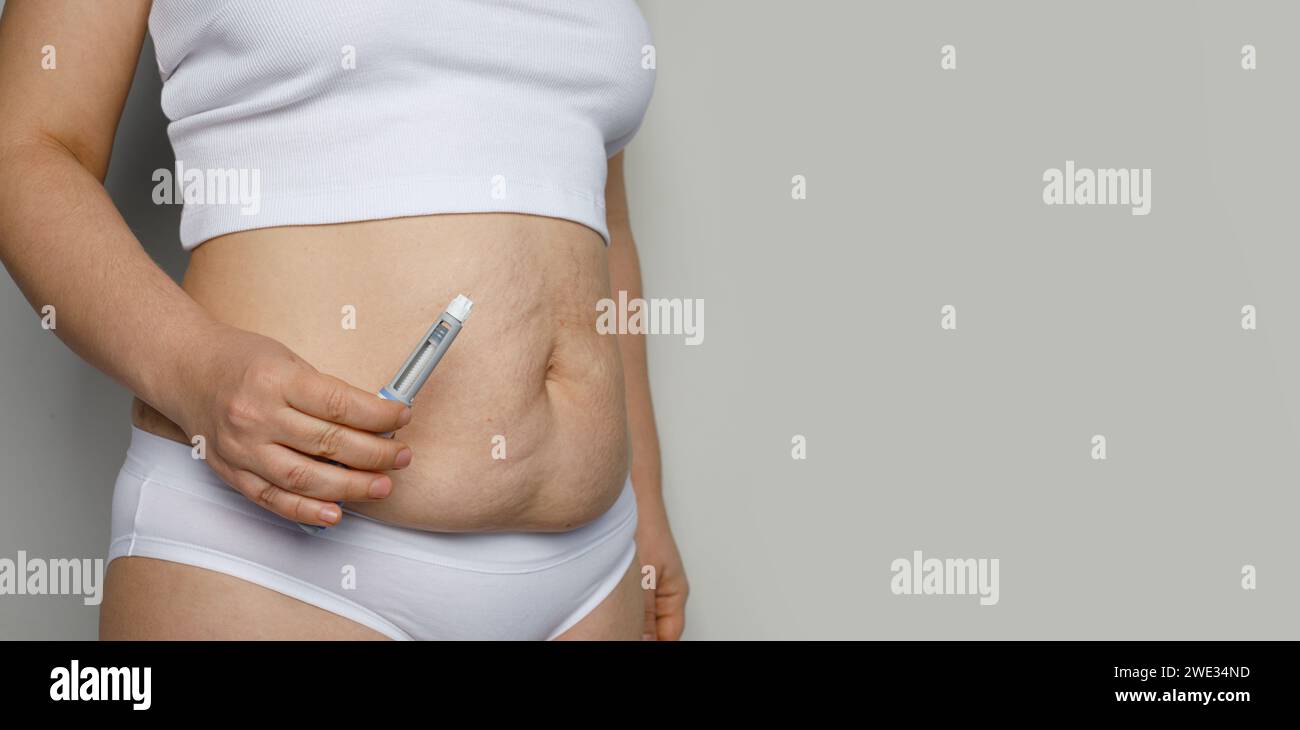 Weibliche Körpernaht mit Semaglutid-Injektions-Pen oder Insulinpatronen-Pen. Medizinische Geräte für Diabetespatienten. Diabetes und Gewichtsreduktion Konzept. Stockfoto