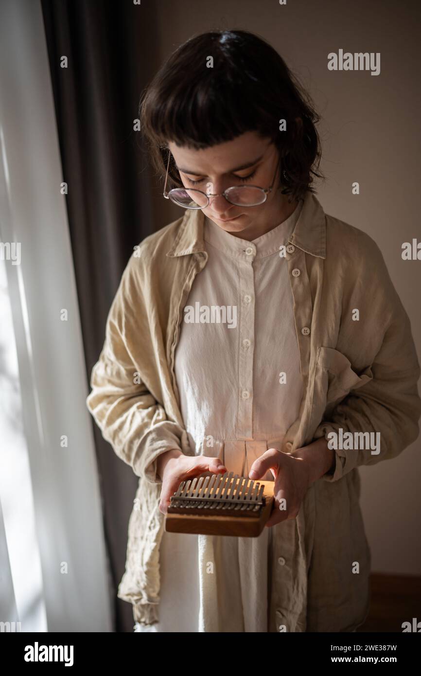 Teenager-Improvisation auf dem ethnischen Schlaginstrument Kalimba. Klangtherapie, Melodiemeditation Stockfoto