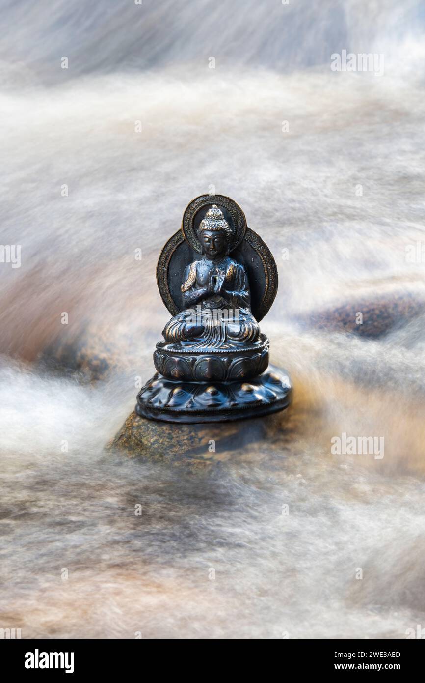 Buddha-Statue in den schnell fließenden Gewässern des Flusses Findhorn. Morayshire, Schottland Stockfoto