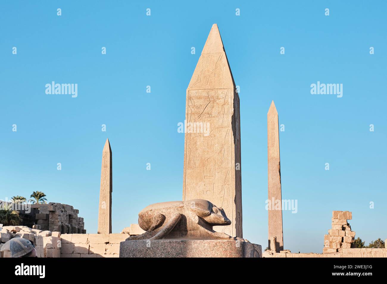 Luxor, Ägypten - 26. Dezember 2023: Statue von Khepri, dem heiligen Scarab mit Obelisken im Tempelkomplex Karnak Stockfoto