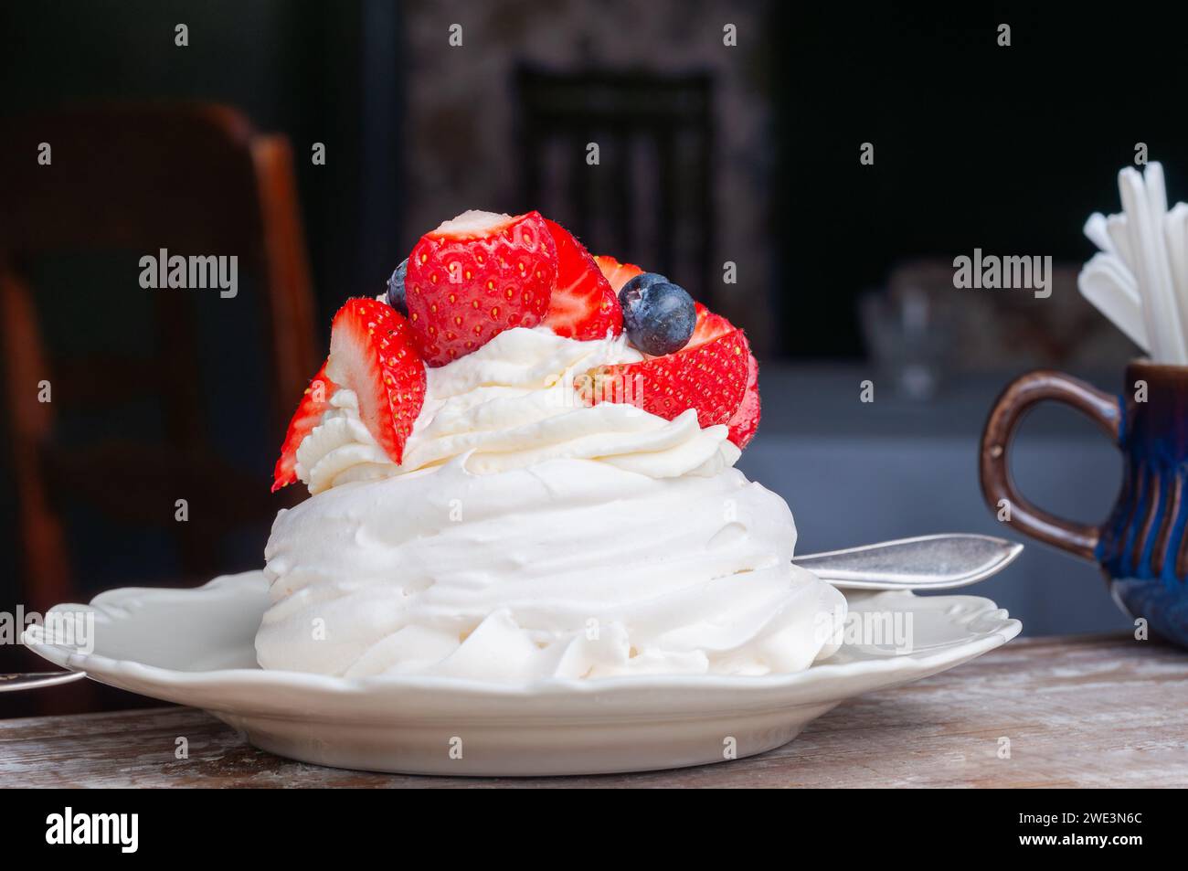 Nachtisch auf Meringue-Basis. Mini Pavlova mit Erdbeere und Heidelbeere. Weichzeichner. Selektiver Fokus. Stockfoto
