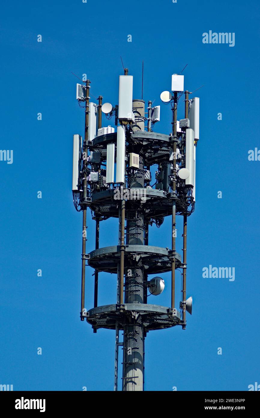 Ein moderner Handymast in Deutschland. Viele Antennen vor einem blauen Himmel. Stockfoto