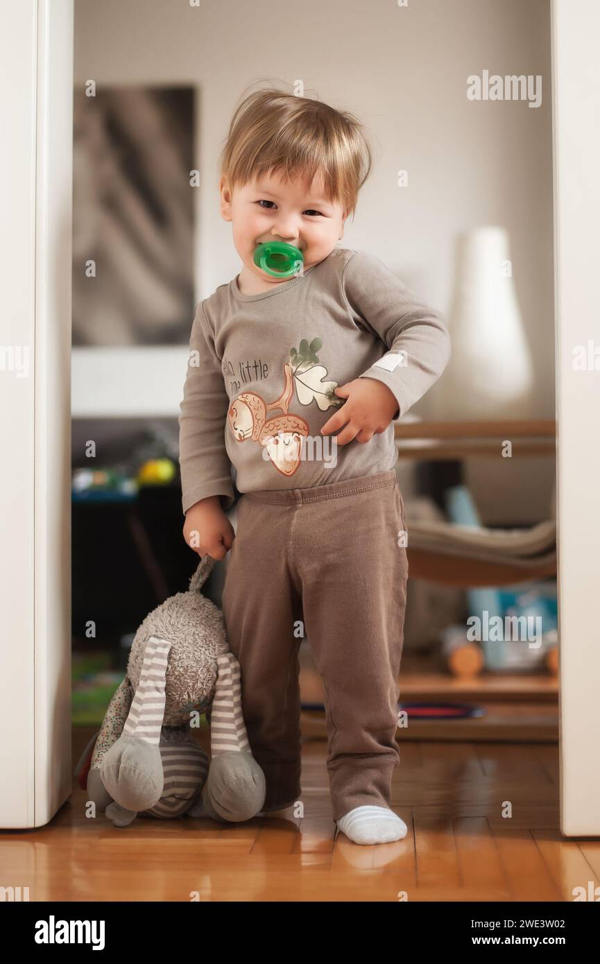 Zärtlicher Moment zwischen einem glücklichen, süßen Jungen und seinem Lieblings-Plüschtier. Untergeordnetes Konzept Stockfoto