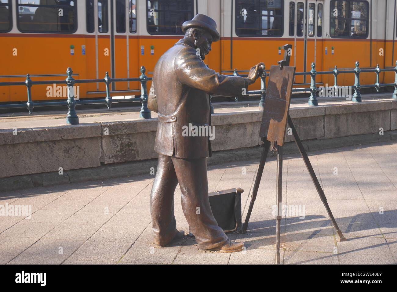 Lebensgroße Bronzestatue des ungarischen - Transkarpaten-Künstlers Ignác Roskovics, Straßenbahnlinie 2 dahinter, Donaudamm, Budapest, Ungarn Stockfoto