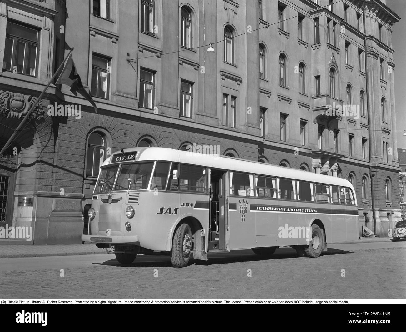 Die Firma Hägglund und Söhne in Örnsköldsvik. Zu dieser Zeit firmierte das Unternehmen unter dem Namen Tischlerei Fabrik, mit der Herstellung von Bussen, Straßenbahnen usw. Das Foto wurde in Nybrokajen in Stockholm aufgenommen, wobei einige der Boote der Firma Waxholm auf der rechten Seite sichtbar waren. Das dramatische Theatergebäude ist auf der linken Seite zu sehen. Ein Scania Vabi-Bus, in dem Hägglund und Söhne 1949 die Karosserie und das Innere bauten. Der Bus mit der Registrierungsnummer A654 ist mit dem Emblem und dem Logo der Airline SAS gekennzeichnet. Kristoffersson Ref. 238A-27 Stockfoto