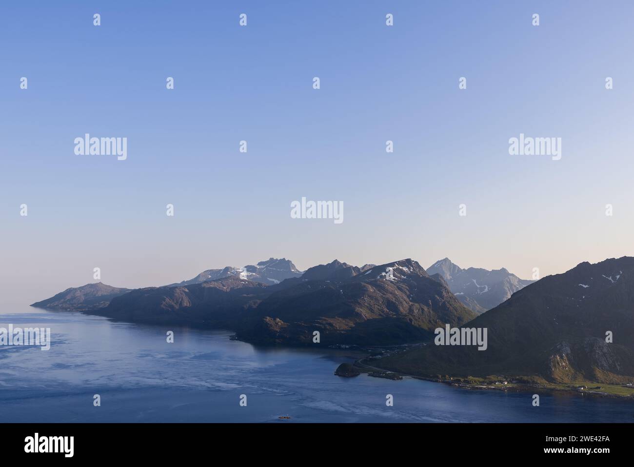 Das sanfte Licht der Abenddämmerung hebt die majestätischen Gipfel und das ruhige Wasser der Lofoten in Norwegen hervor und schafft eine friedliche Harmonie zwischen Land Stockfoto