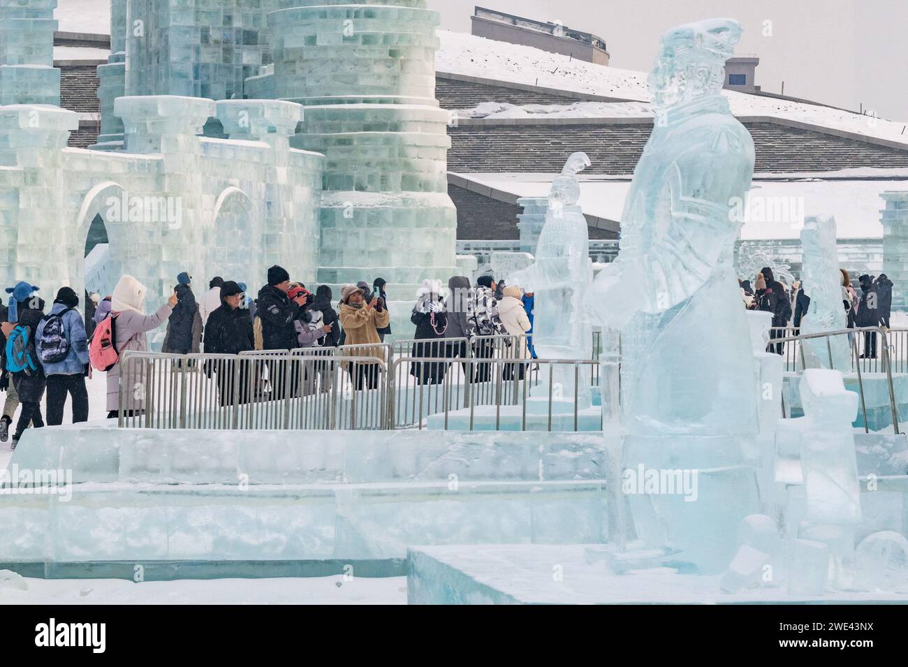 Harbin, Chinas Provinz Heilongjiang. Januar 2024. Besucher sehen Eisskulpturen der Terrakotta-Krieger in Harbin Ice and Snow World in Harbin, nordöstlicher chinesischer Provinz Heilongjiang, 23. Januar 2024. Als eine Gruppe von KI-generierten Bildern von Eisskulpturen der Terrakotta-Krieger im Internet viral wurde, schufen Künstler eine Reihe von Eisskulpturen der Terrakotta-Krieger in Harbin Ice and Snow World, um Besucher anzulocken. Quelle: Xie Jianfei/Xinhua/Alamy Live News Stockfoto