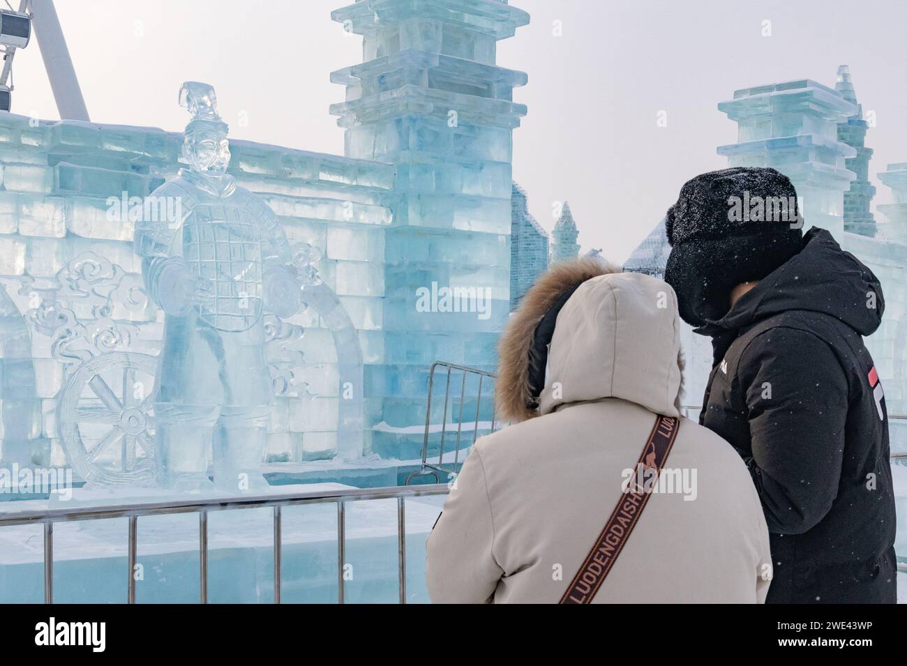 Harbin, Chinas Provinz Heilongjiang. Januar 2024. Besucher sehen eine Eisskulptur eines Terrakotta-Kriegers in Harbin Ice and Snow World in Harbin, nordöstlicher chinesischer Provinz Heilongjiang, 23. Januar 2024. Als eine Gruppe von KI-generierten Bildern von Eisskulpturen der Terrakotta-Krieger im Internet viral wurde, schufen Künstler eine Reihe von Eisskulpturen der Terrakotta-Krieger in Harbin Ice and Snow World, um Besucher anzulocken. Quelle: Xie Jianfei/Xinhua/Alamy Live News Stockfoto