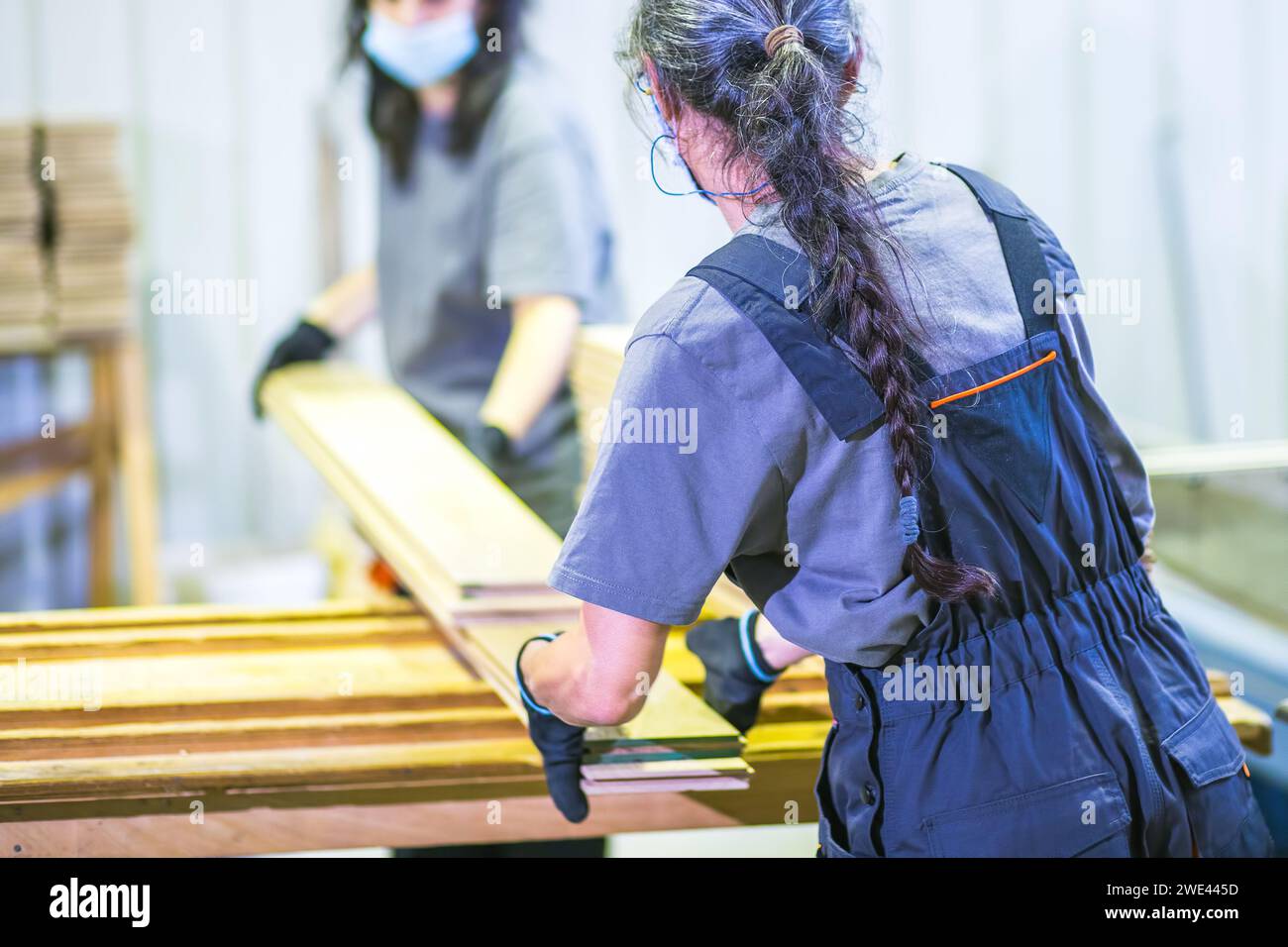 Arbeitnehmerinnen, die mit Dielen in Holzverarbeitungsfabriken arbeiten Stockfoto