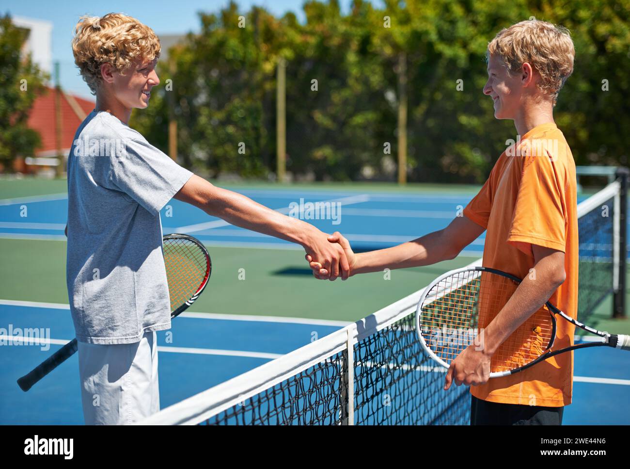 Spieler, Tennis und Handshake mit Spiel, Gewinner und Platz mit Freunden, Sportler oder Fitness. Jungs, Outdoor oder Teenager, die sich die Hände schütteln oder Wettkämpfe machen Stockfoto