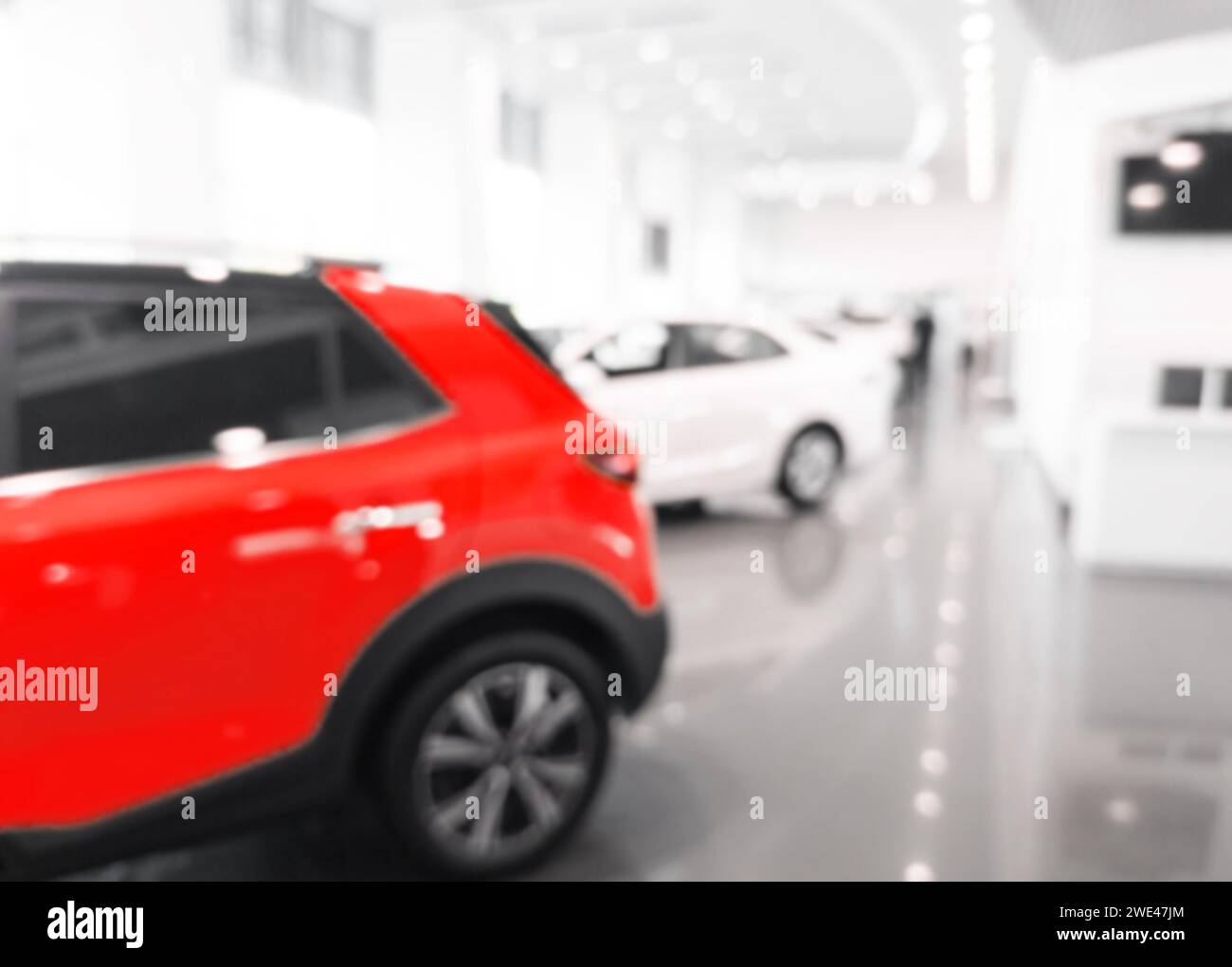 Verschwommener Hintergrund im Innenraum des Autohauses. Verschwommenes abstraktes Händlergeschäft mit defokussierten Autos. Blur Bokeh Transport Concept Dealer Stockfoto