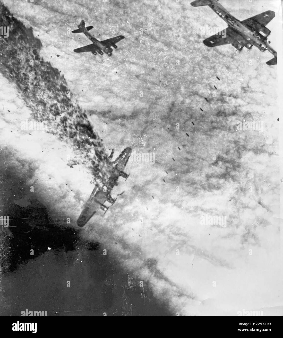 DIE BOEING B-17G der USAAF 834th Bombardment Squadron, die von der RAF Sudbury aus in England fliegt, trifft am 2. November 1944 direkt von Flak auf einer Mission über Deutschland. Die anderen Flugzeuge werfen Bomben durch die Wolke, nachdem das Ziel durch den Hauptbomber angepasst wurde. Foto von S/Sgt Bill Stewart aus seinem Hüftfenster. Stockfoto