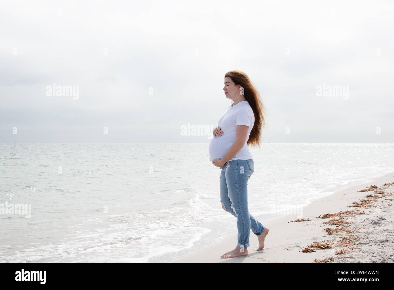 Schwangere Frau genießt den Ozean. Schwangere Frau am Strand. Glückliche gesunde Schwangerschaft. Wellness-Konzept Stockfoto